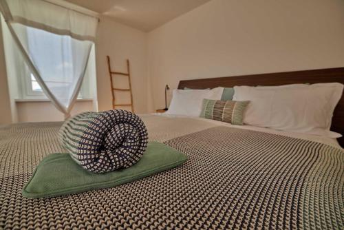 a hat sitting on top of a bed at Osteria Manciana con Alloggio MONTE GENEROSO in Scudellate