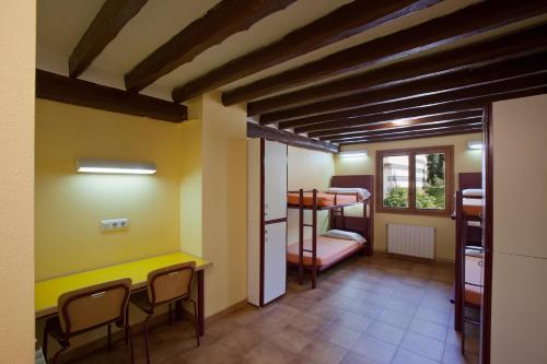 a room with a bunk bed and a table and chairs at Alberg La Molina Xanascat in La Molina