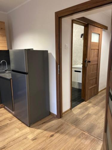 a kitchen with a stainless steel refrigerator and a door at Apartamenty Bezrzecze in Szczecin