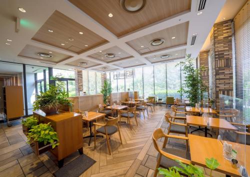 un restaurante con mesas, sillas y ventanas en Ours Inn Hankyu, en Tokio