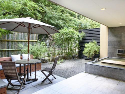 a patio with a table and chairs and an umbrella at Fufu Atami in Atami