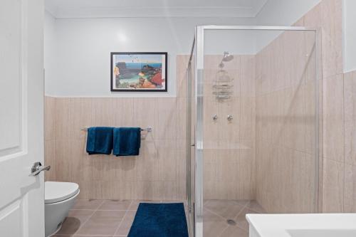a bathroom with a shower and a toilet at Cardwell Seascape Apartments in Cardwell