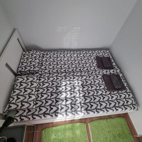 a room with a bed with black and white at GOX Apartman in Subotica