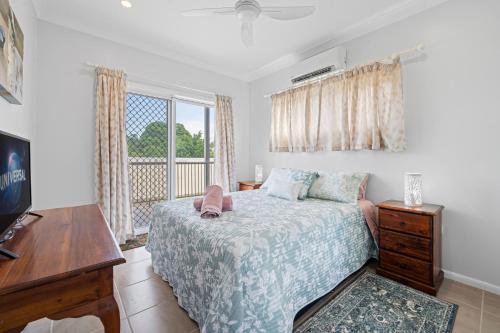 a bedroom with a bed and a window at Cardwell Seascape Apartments in Cardwell
