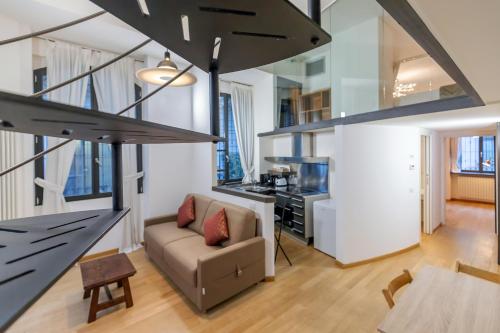 Ce loft comprend un canapé et une cuisine. dans l'établissement Milan Retreats Navigli, à Milan