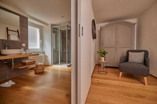 a bathroom with a sink and a chair in a room at Osteria Manciana con Alloggio MONTE GENEROSO in Scudellate