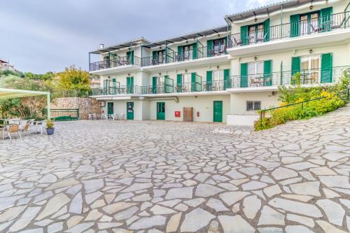 a building with a stone courtyard in front of it at Vergina Star Hotel in Nikiana