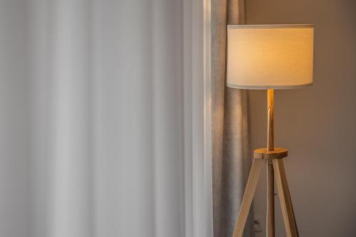 a lamp sitting in a room next to a curtain at Milano Ostend - Casselbergh Residences in Ostend