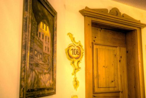 a clock on a wall next to a door at Hotel Hölzer Bräu by Lehmann Hotels in Ebersberg
