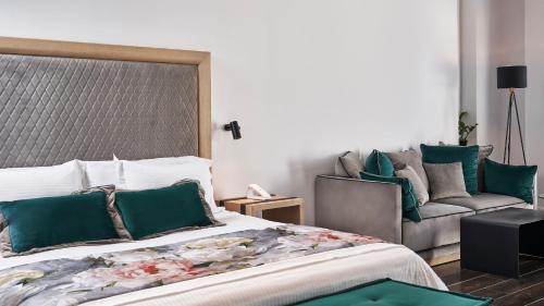 a bedroom with a large bed and a couch at Katikies Garden Santorini - The Leading Hotels Of The World in Fira