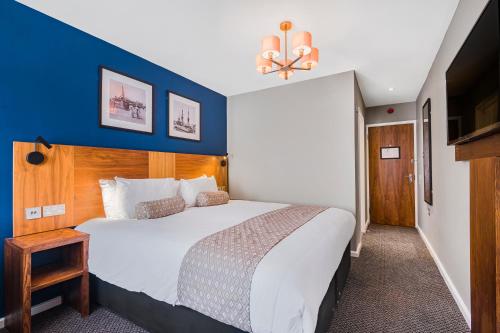 a bedroom with a large bed with a blue wall at The Red Lion by Innkeeper's Collection in Portsmouth