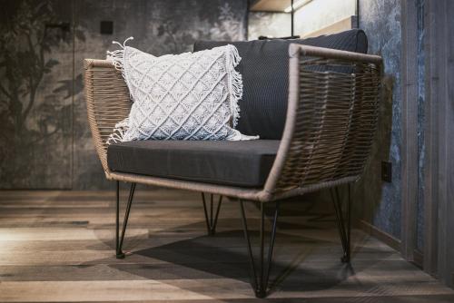 a wicker chair with a pillow on it in a room at Margarethenstein Boutique Hotel in Kaprun