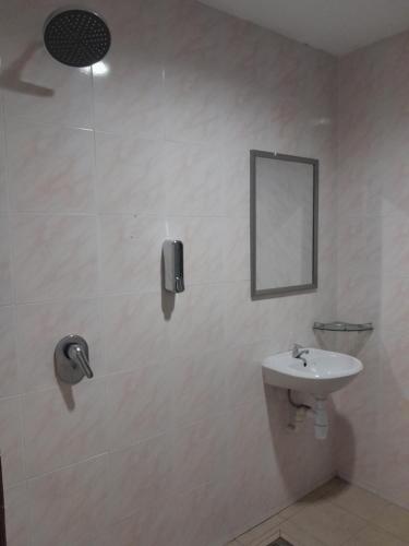 a white bathroom with a sink and a mirror at The great in Ipoh