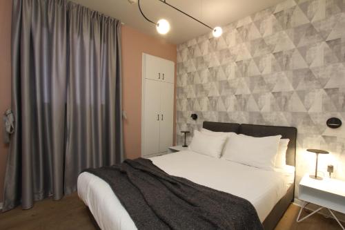 a bedroom with a large bed with a stone wall at דירות גני תערוכה - TLV university apartments near Expo by Sea N' Rent in Tel Aviv