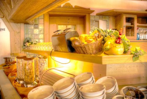 a kitchen counter with plates and dishes on a shelf at Hotel Hölzer Bräu by Lehmann Hotels in Ebersberg