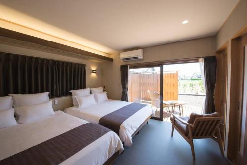 Habitación de hotel con 2 camas y balcón en Jikukan Enishi en Taisha