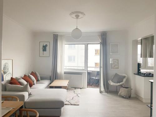 Sala de estar blanca con sofá y mesa en An cosy apartment near CPH airport en Copenhague