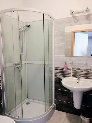 a bathroom with a glass shower and a sink at Mini Hotel Akord in Ostrava