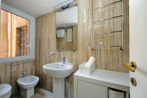 a bathroom with a sink and a toilet and a mirror at suity I cozy Nazareno Apartment in Rome