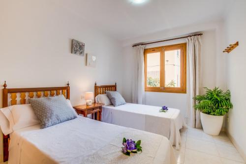 a bedroom with two beds and a couch and a window at Ideal Property Mallorca - Tobalu in Colonia Sant Jordi