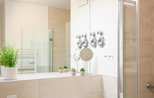 a bathroom with a shower with a mirror and potted plants at Chic Studio : Super Zentral : 1min zum HBF in Mannheim