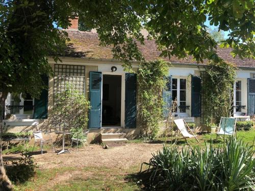 une maison avec une porte bleue et des chaises dans la cour dans l'établissement Country house - 5 mns from Fontainebleau, 