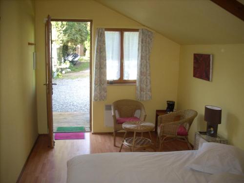 1 dormitorio con 1 cama, mesa y sillas en B&B Les Bergers, en Braine-lʼAlleud
