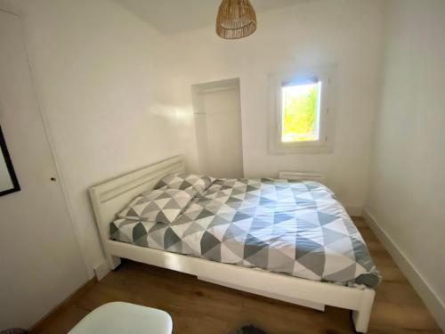 une petite chambre avec un lit et une fenêtre dans l'établissement Appartement cozy, à Montpellier