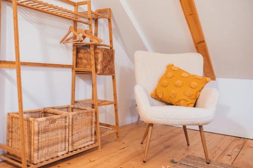 einen Stuhl mit einem gelben Kissen neben einem Regal in der Unterkunft Ograda Magura village in Măgura