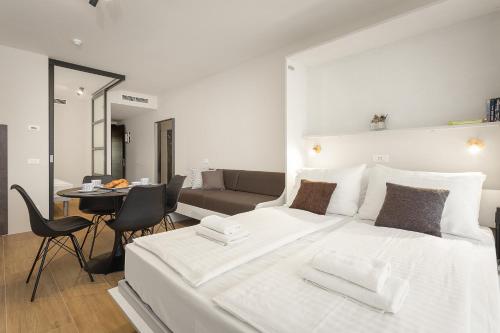 una camera con un grande letto bianco e un soggiorno di Residence Del Mar Emotion a Pola (Pula)
