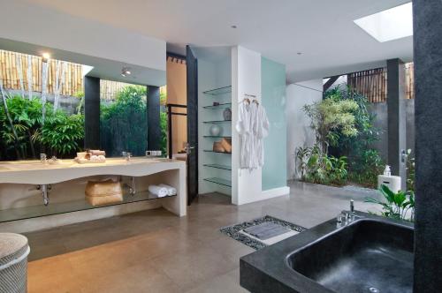 a bathroom with a large tub and a sink at Villa Alice in Seminyak