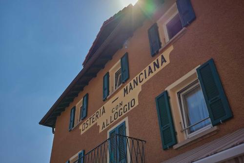 a sign on the side of a building at Osteria Manciana con Alloggio MONTE GENEROSO in Scudellate