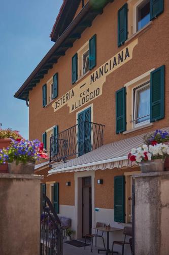 a building with a sign on the side of it at Osteria Manciana con Alloggio MONTE GENEROSO in Scudellate