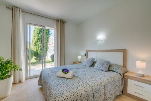 a bedroom with a bed and a large window at Ideal Property Mallorca - El Sol in Alcudia