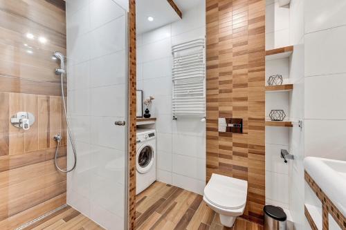 uma casa de banho com um WC e uma máquina de lavar roupa em Downtown Apartments Sea View Trzy Żagle em Gdansk