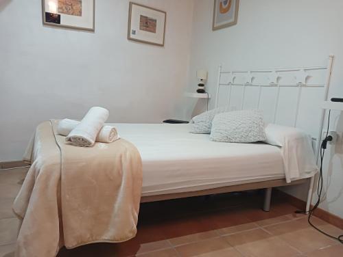 a bed with two pillows and a blanket on it at Cau d'en Magí - Apartament Casc Antic in Tarragona