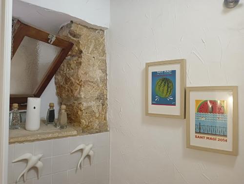 baño con espejo y una foto en la pared en Cau d'en Magí - Apartament Casc Antic, en Tarragona