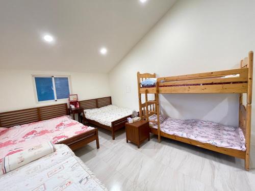 a bedroom with two bunk beds in a room at Star & Moon GUEST HOUSE in Hengchun South Gate