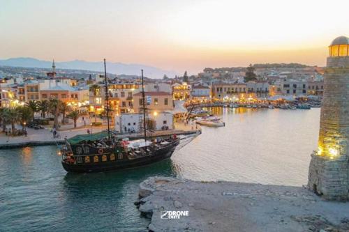 a boat in the water next to a city at Calergi Residence - Holidays in Crete in Atsipopoulo