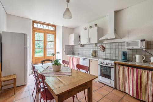 - une cuisine avec une table et des chaises en bois dans l'établissement Villa de luxe à Salies + piscine privée, à Saliès