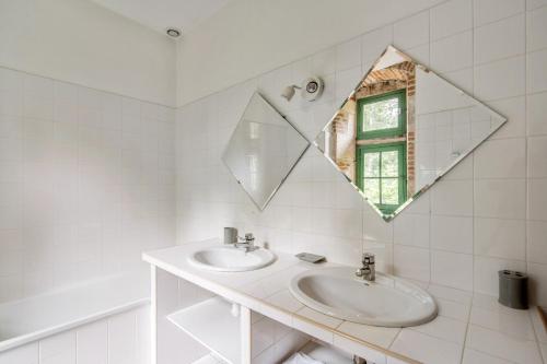 un bagno bianco con due lavandini e uno specchio di Villa de 6 chambres avec piscine privee jardin clos et wifi a Salies a Saliès