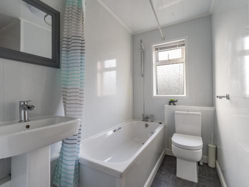 uma casa de banho com uma banheira, um WC e um lavatório. em Chestnut House - Cosy 2 bedroom - Ashington em Ashington