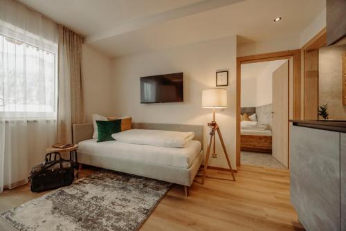 フラッハウにあるAppartement Wiederkehrのベッドとテレビが備わるホテルルームです。