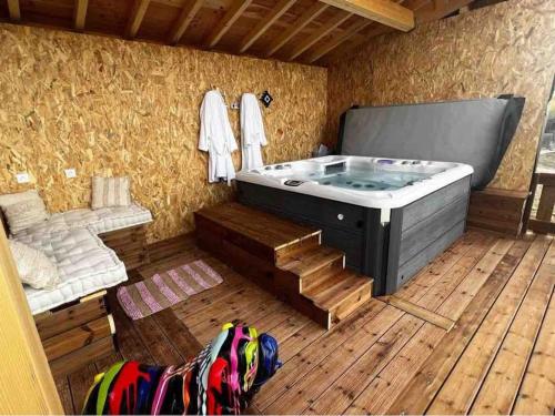 Gite à la ferme avec jacuzzi et piscine chauffée في Saint-Félix-de-Tournegat: جاكوزي في غرفة مع أرضية خشبية
