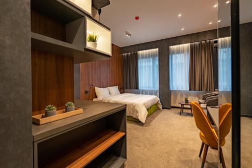 Habitación de hotel con cama y escritorio en Hotel Element en Novi Sad