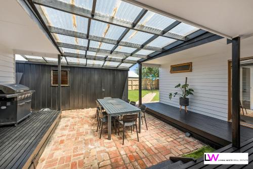 a patio with a table and a grill at Ocean Grove Beach House in Ocean Grove