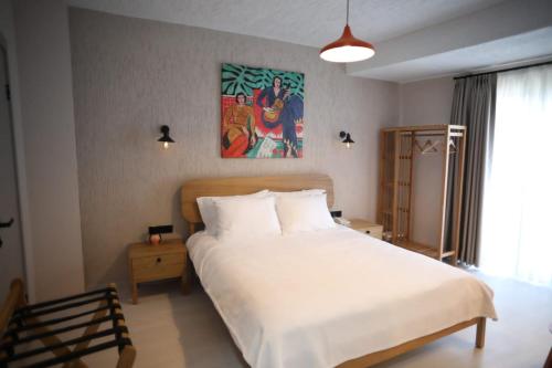 a bedroom with a white bed and a painting on the wall at Mare House Boutique Hotel in Bursa