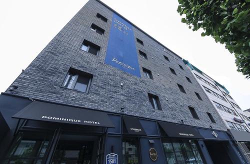 a building with a sign on the side of it at Sillim Dominique Hotel in Seoul