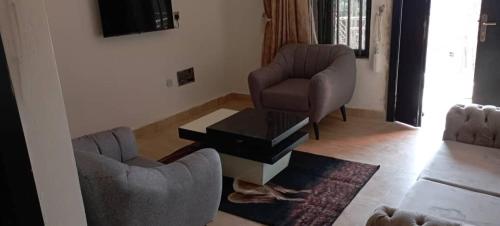 a living room with two chairs and a coffee table at Remarkable 2-Bed Apartment in Asaba in Asaba