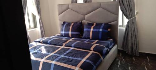1 dormitorio con 1 cama con edredón y almohadas azules en Remarkable 2-Bed Apartment in Asaba, en Asaba